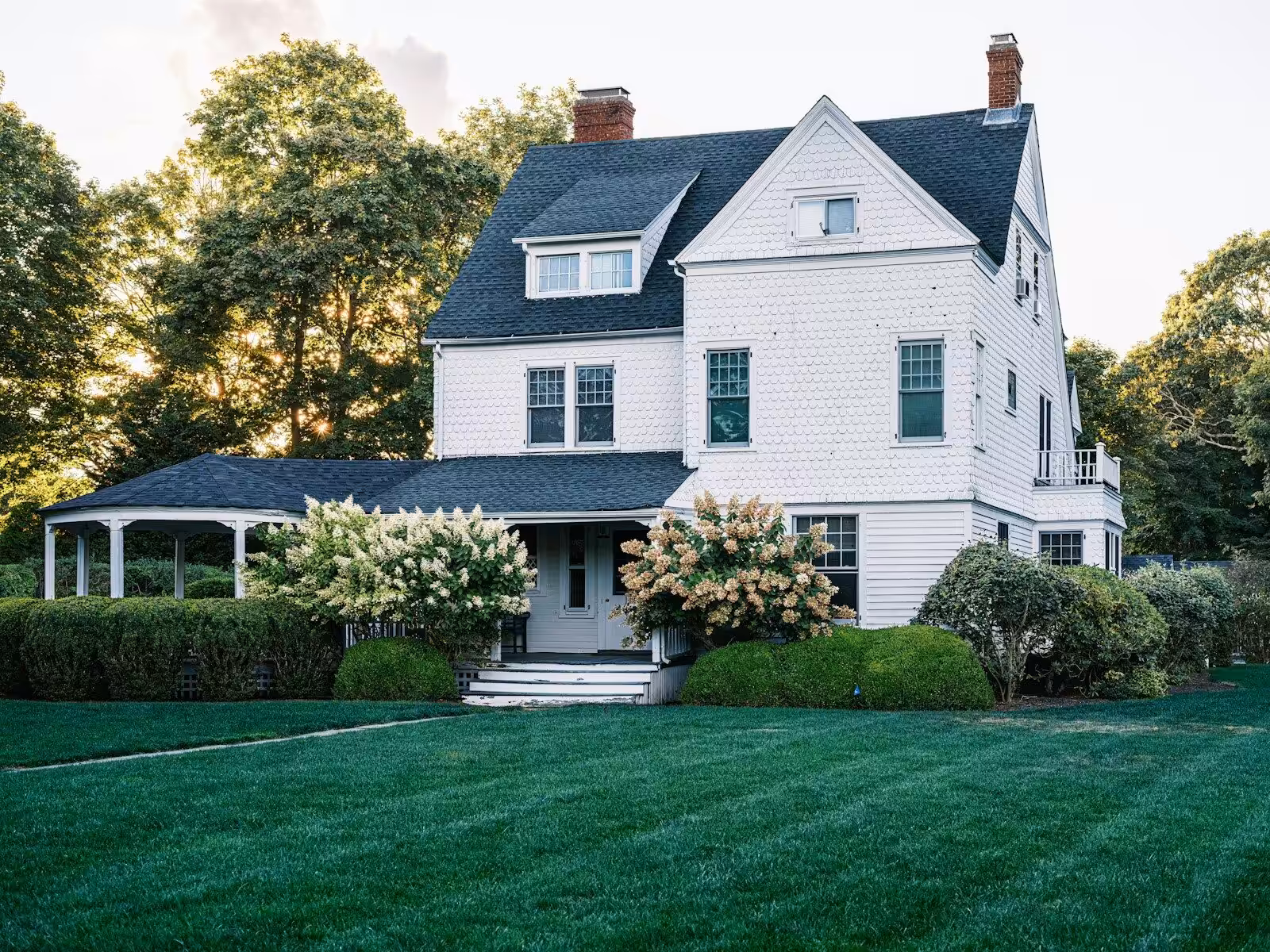A large white house with a green lawn.